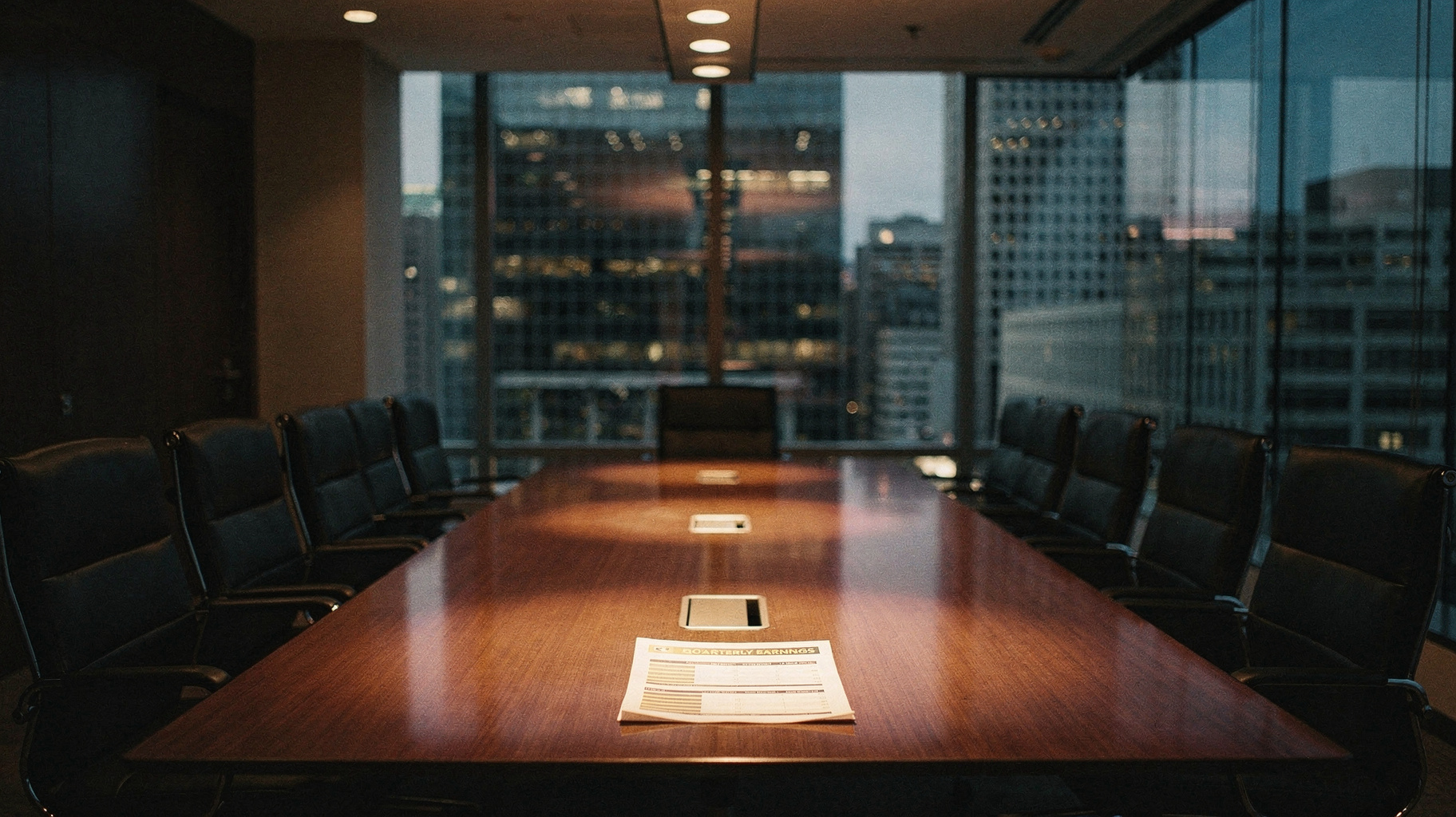 A documentary photograph of an empty investment-bank boardroom at dusk, a single printed quarterly earnings sheet left face-up at the head of a long table, city towers dimming behind floor-to-ceiling glass